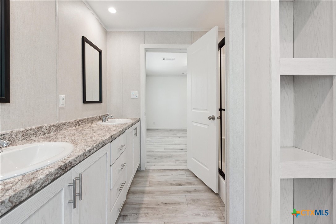 855 Roosevelt Road Luling, TX 78648 - Photo 23 of 47 a bathroom with a granite countertop sink and a mirror