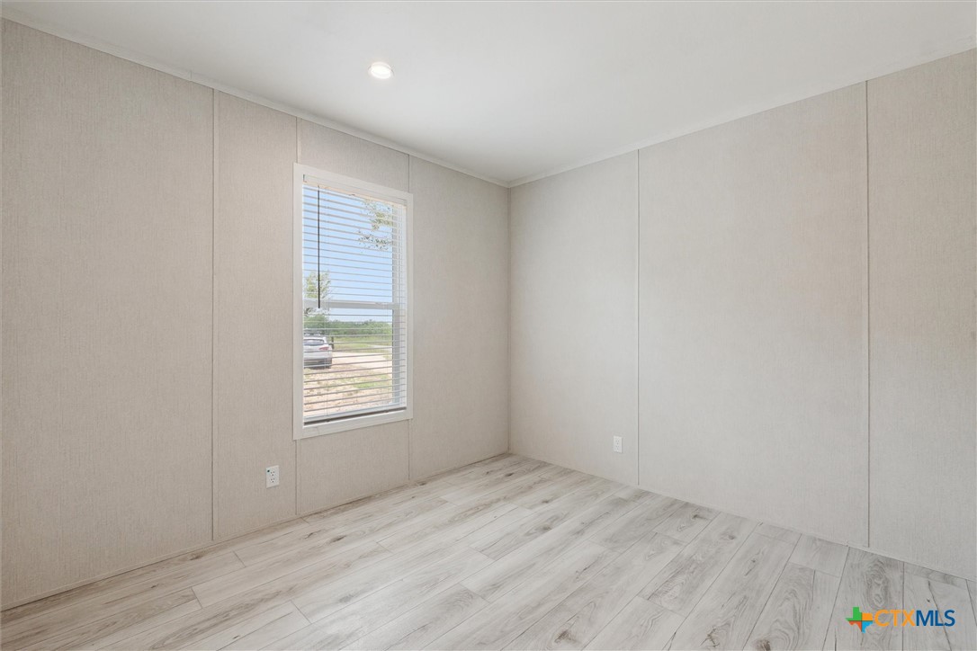855 Roosevelt Road Luling, TX 78648 - Photo 25 of 47 an empty room with wooden floor and windows