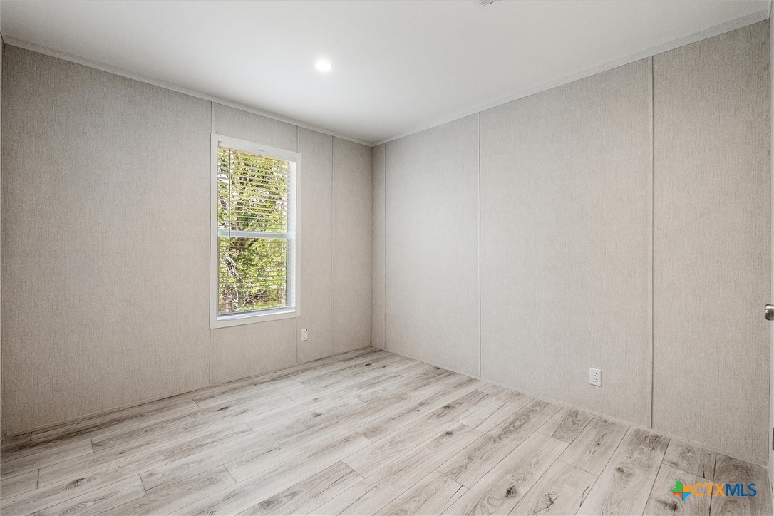 855 Roosevelt Road Luling, TX 78648 - Photo 30 of 47 an empty room with wooden floor and windows