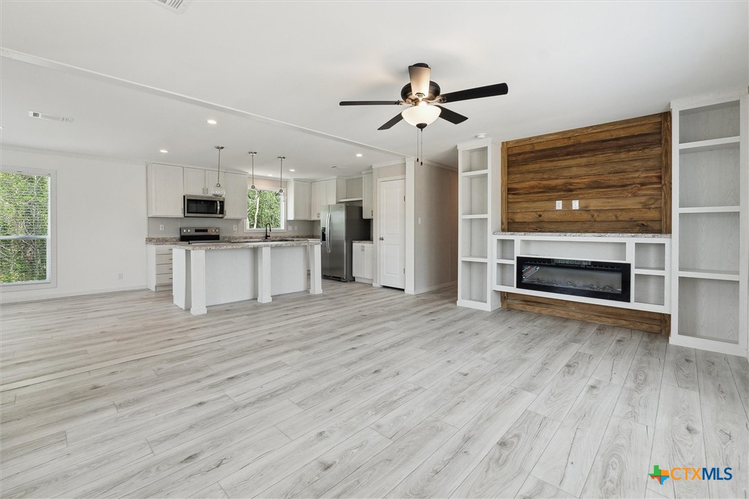 855 Roosevelt Road Luling, TX 78648 - Photo 6 of 47 a view of a kitchen with wooden floor and a ceiling fan