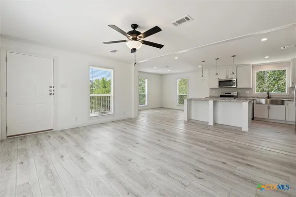 a view of kitchen with wooden floor and electronic appliances