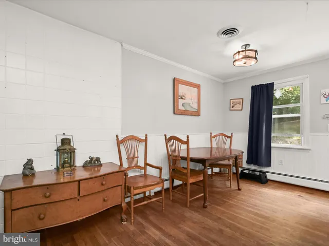 a living room with furniture a wooden floor and next to a window