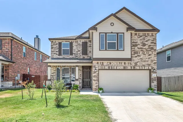 a front view of a house with a yard and garage
