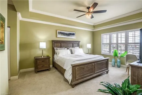 a bedroom with a bed flat screen tv and a large window