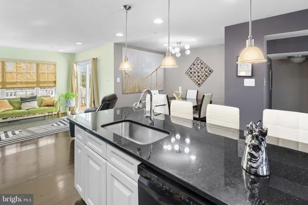 a large kitchen with granite countertop a large center island attached withe living room