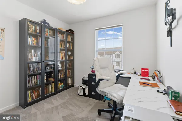 a view of a workspace with furniture and a window