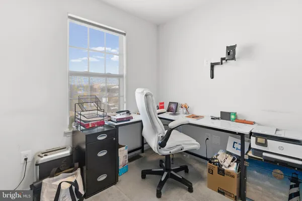 a view of a workspace with furniture and a window