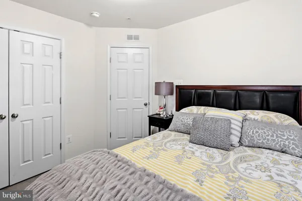a bedroom with a large bed and wooden floor