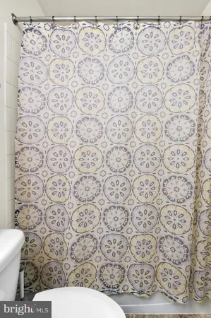 a bathroom with a toilet and a shower curtain