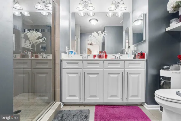 a bathroom with a sink mirror and a shower