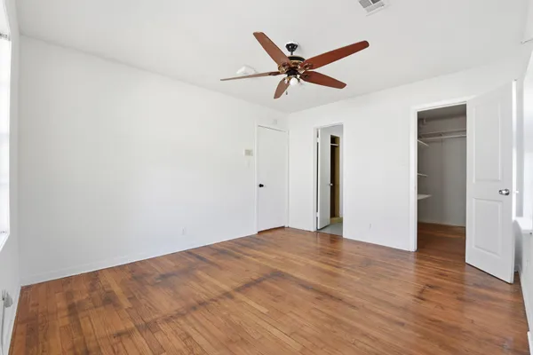 a view of a big room with wooden floor and windows