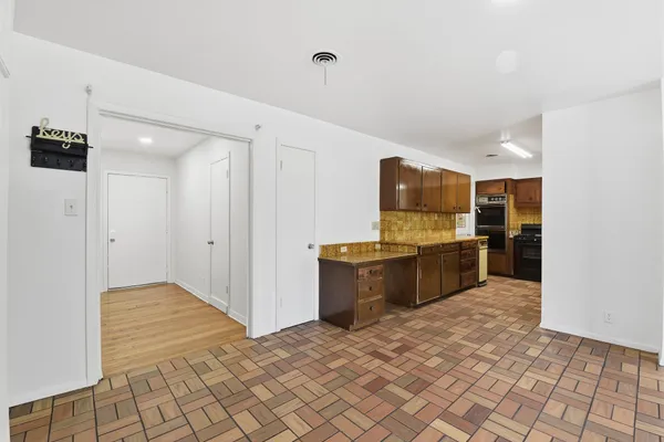 a kitchen with granite countertop a refrigerator and a stove top oven