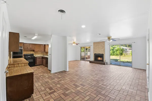 an empty room with windows and fireplace