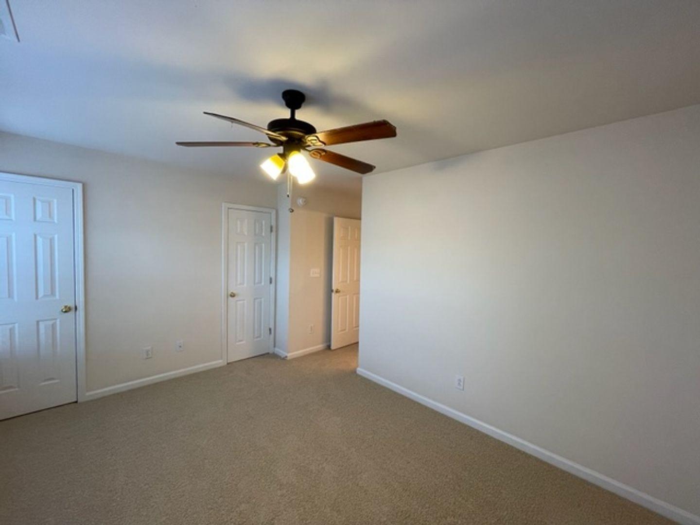 1672 Brook Fern Way Raleigh, NC 27609 - Photo 11 of 14 an empty room with a chandelier fan and a ceiling fan