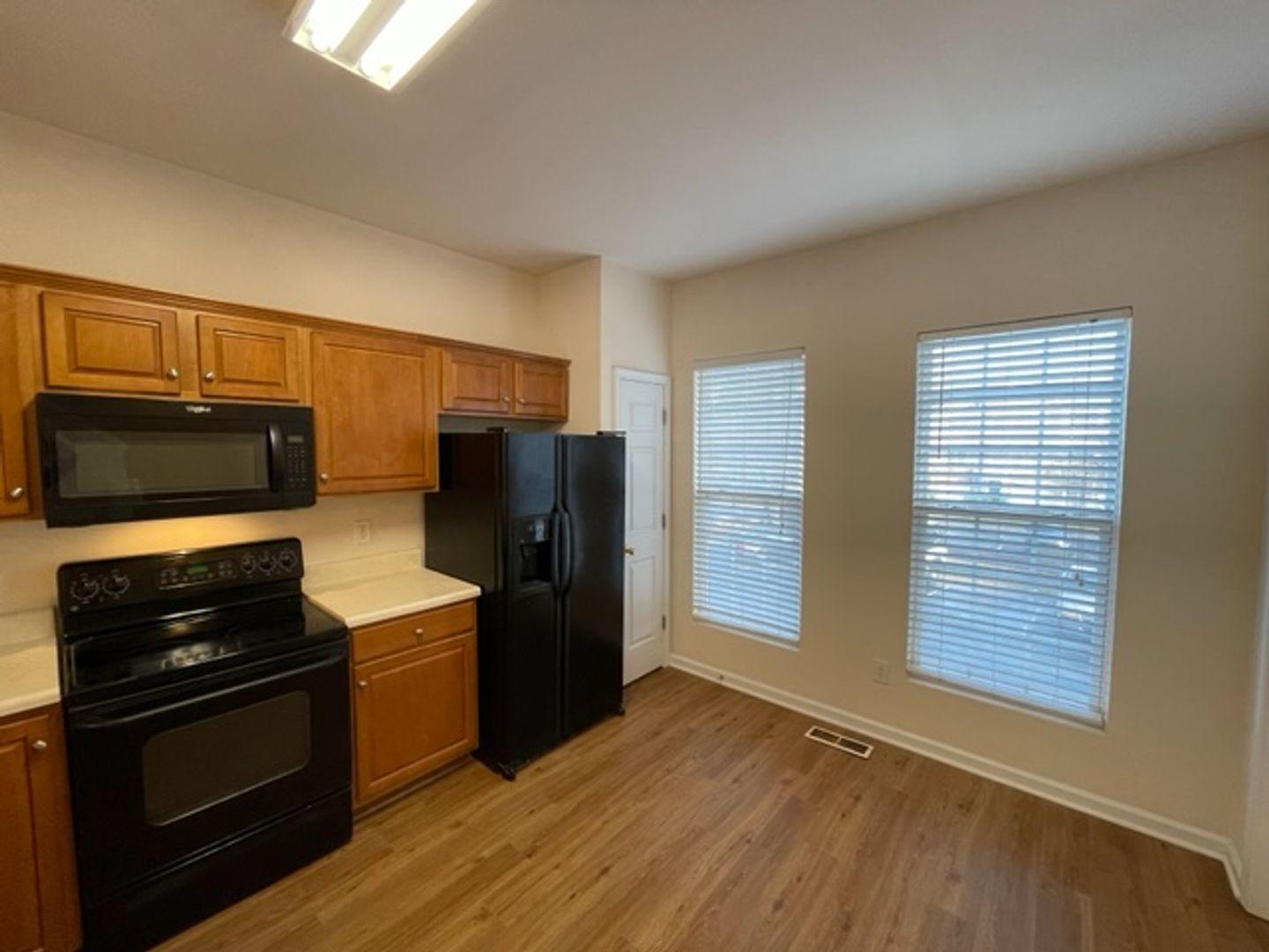 1672 Brook Fern Way Raleigh, NC 27609 - Photo 6 of 14 a kitchen with a refrigerator stove and wooden cabinets