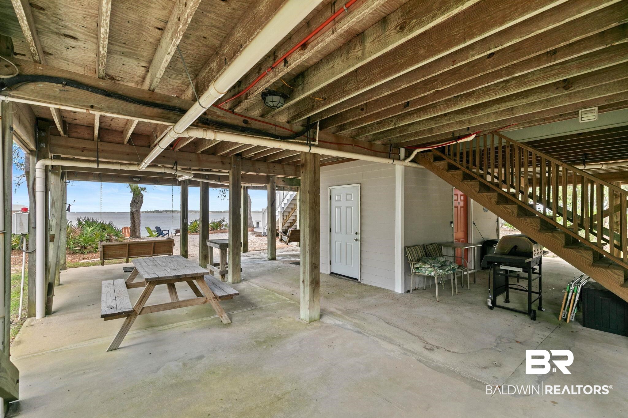 6802 Shore Drive Elberta, AL 36530 - Photo 25 of 34 Covered ground level with concrete flooring, exposed wood beam ceiling, and visible water scenery