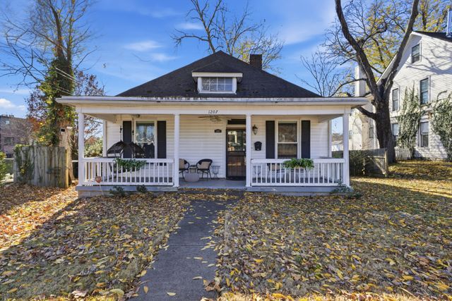 a view of a house with a small yard and wooden fence