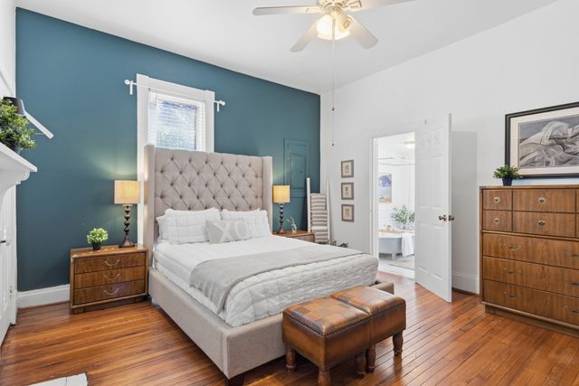 a bedroom with a large bed and a chandelier