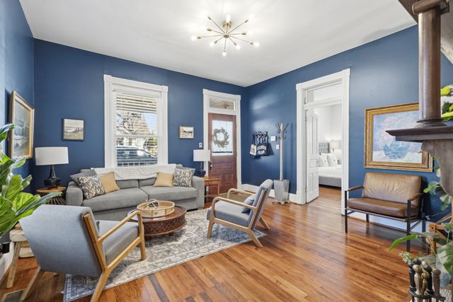 a living room with furniture and a wooden floor