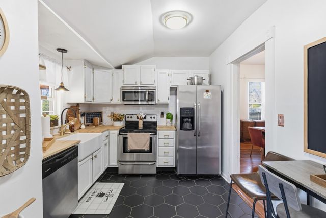a kitchen with stainless steel appliances a refrigerator sink and cabinets