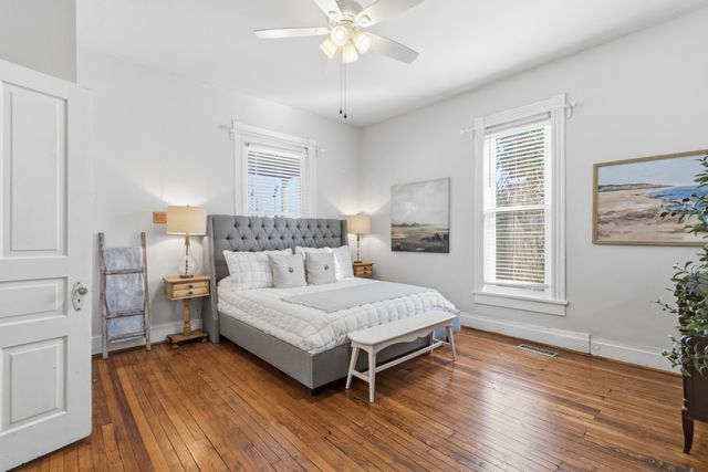 a bedroom with a bed and wooden floor