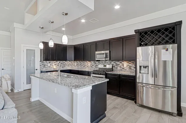 a kitchen with granite countertop a sink and a stove top oven with wooden floor