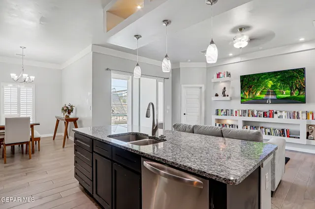 a kitchen with kitchen island granite countertop a sink stove and cabinets