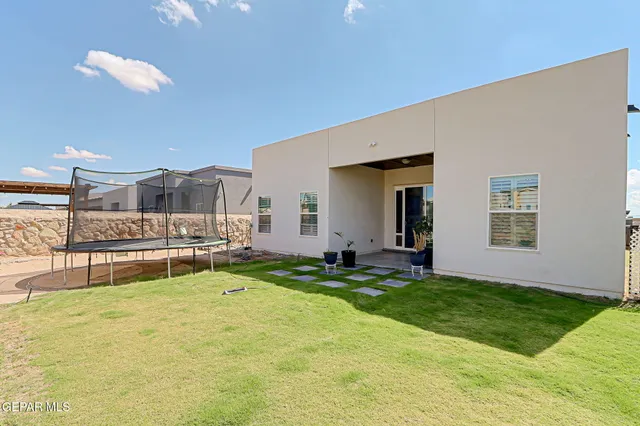 a living room with a floor to ceiling window and kitchen view
