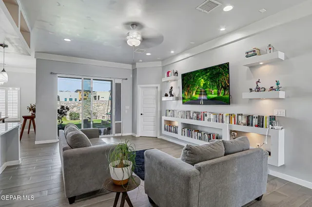 a living room with stainless steel appliances furniture a rug and a kitchen view