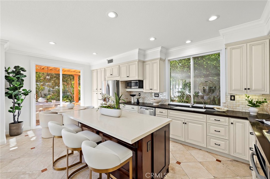 18 Bel Spring Irvine, CA 92602 - Photo 8 of 44 a kitchen with a stove a sink a dining table and chairs