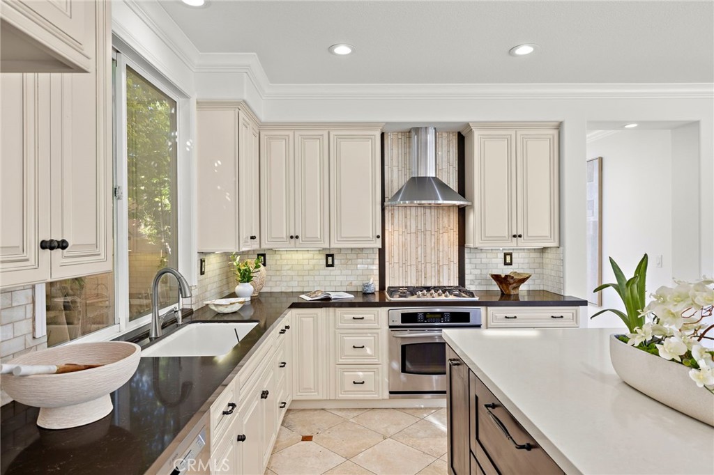 18 Bel Spring Irvine, CA 92602 - Photo 10 of 44 a large white kitchen with a stove a sink and white cabinets with wooden floor