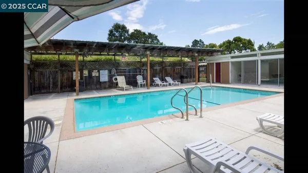 a view of a swimming pool with a patio and a yard