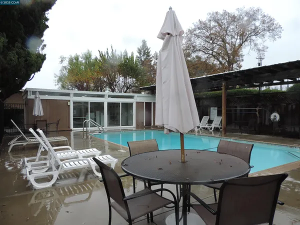 a view of a patio with table and chairs with wooden floor and fence