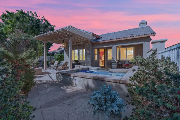 a view of a house with backyard and sitting area