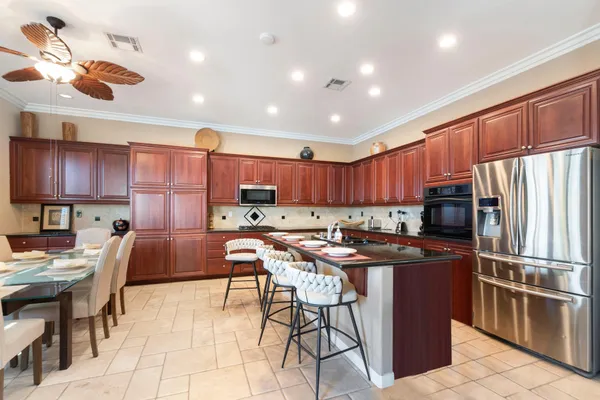 a kitchen with kitchen island granite countertop a sink stove and cabinets