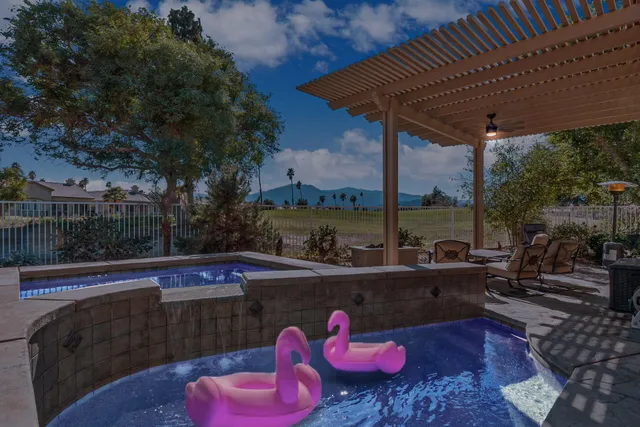 a view of swimming pool with a couches in a patio
