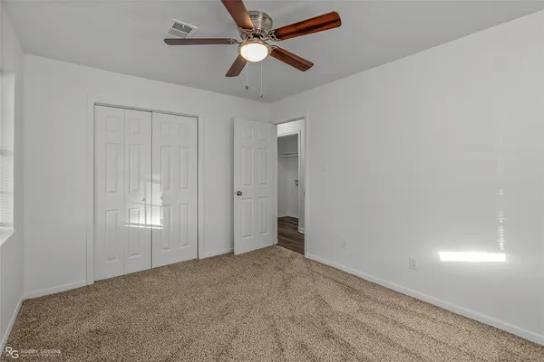 an empty room with closet and windows