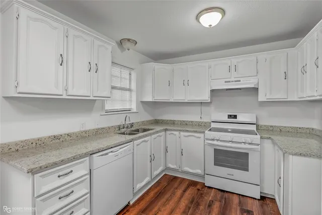 a kitchen with granite countertop white cabinets and white appliances