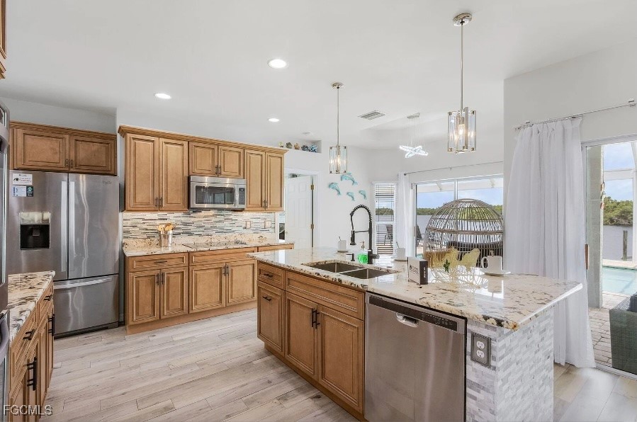4885 East Riverside Drive Fort Myers, FL 33905 - Photo 11 of 45 a kitchen with stainless steel appliances granite countertop a sink stove and refrigerator