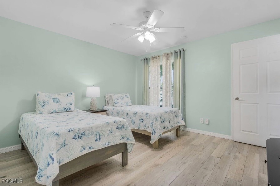 4885 East Riverside Drive Fort Myers, FL 33905 - Photo 26 of 45 a spacious bedroom with two beds and a chandelier
