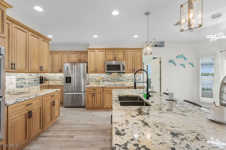 4885 East Riverside Drive Fort Myers, FL 33905 - Photo 8 of 45 a kitchen with stainless steel appliances kitchen island granite countertop a refrigerator and a stove top oven