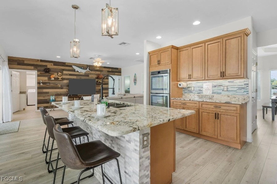 4885 East Riverside Drive Fort Myers, FL 33905 - Photo 10 of 45 a kitchen with kitchen island granite countertop a sink cabinets and wooden floor