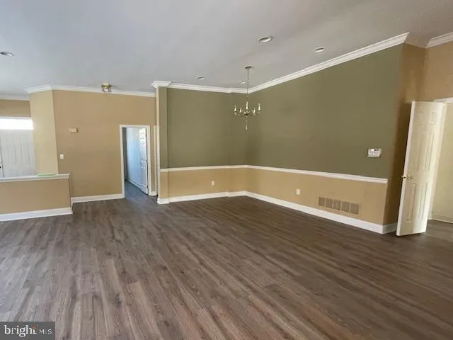 a view of a kitchen center island wooden floor and stainless steel appliances