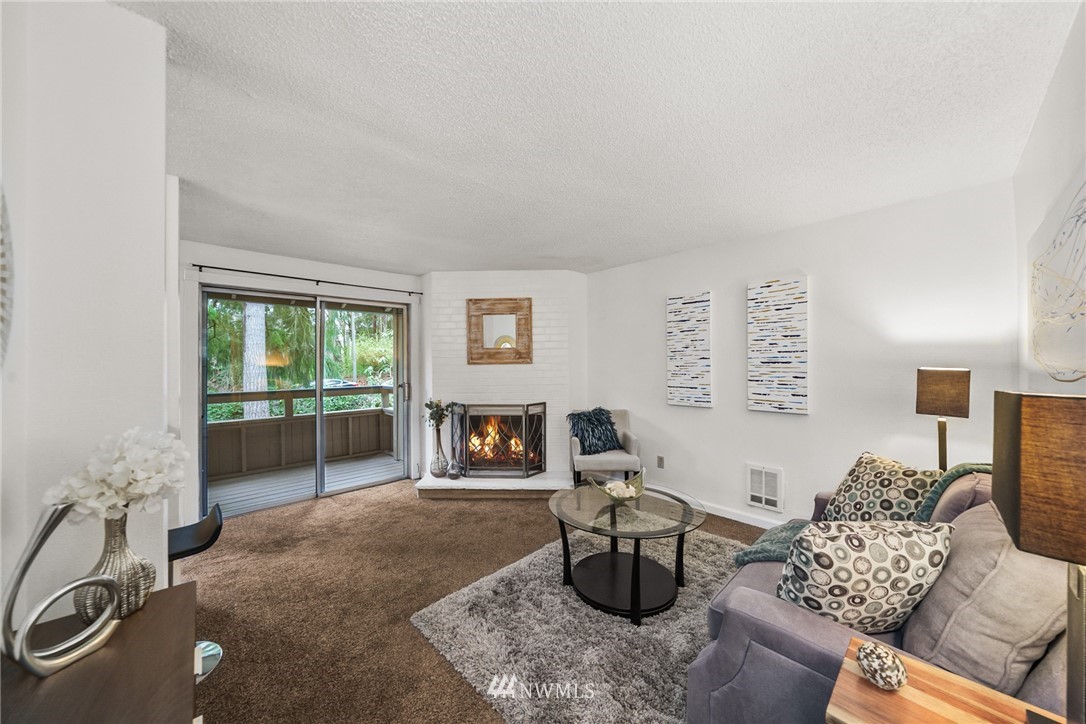 17536 149th Avenue Southeast, Unit O12 Renton, WA 98058 - Photo 3 of 12 a living room with furniture a fireplace and a floor to ceiling window
