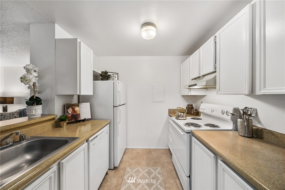 17536 149th Avenue Southeast, Unit O12 Renton, WA 98058 - Photo 6 of 12 a kitchen with a sink stove and refrigerator