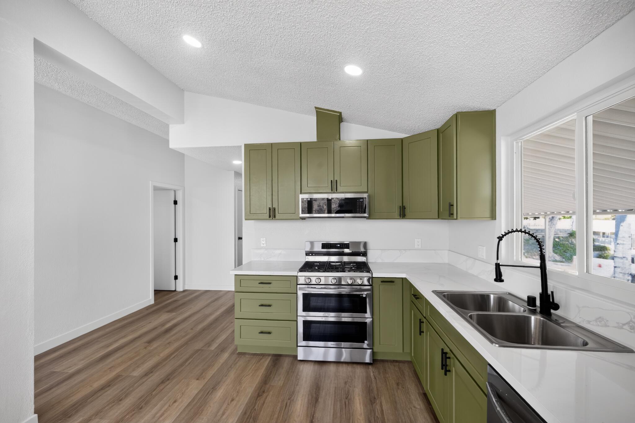 15181 Van Buren Boulevard, Unit 102 Riverside, CA 92504 - Photo 14 of 29 a kitchen with stainless steel appliances a stove sink and cabinets