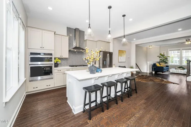 a kitchen with kitchen island wooden floors white appliances and cabinets