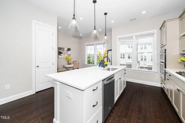 a large kitchen with kitchen island a stove a sink a center island and wooden floor