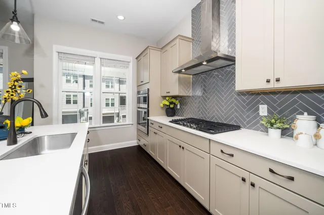 a large kitchen with stainless steel appliances a large center island attached withe living room