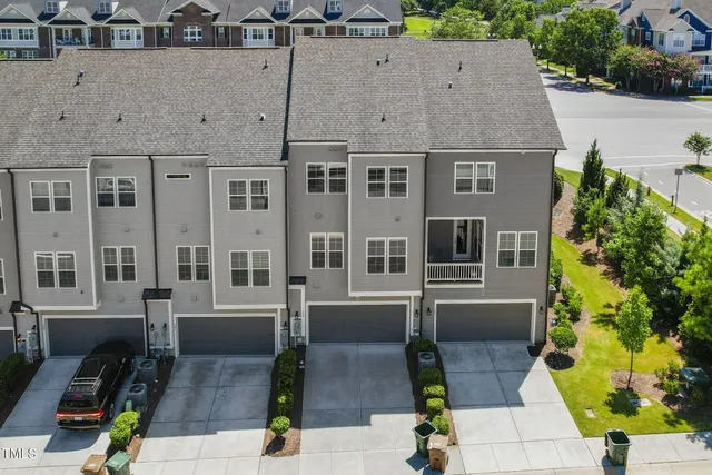 a view of backyard with a car park in front of it